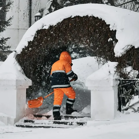 Winterdienst räumt Schnee vor einem Hauseingang